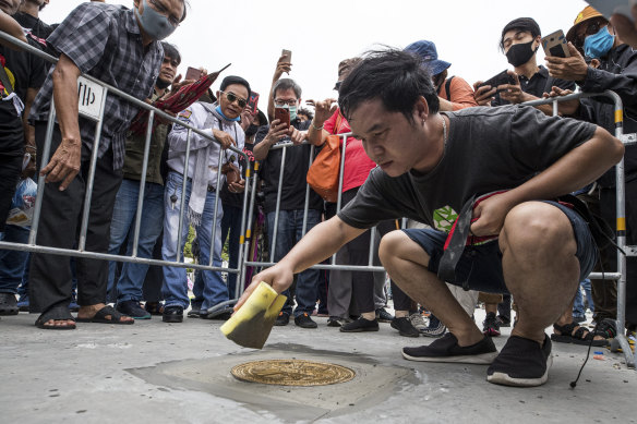 A pro-democracy supporter fixes a plaque which declares "This country belongs to the people" during a protest in Bangkok on Sunday.