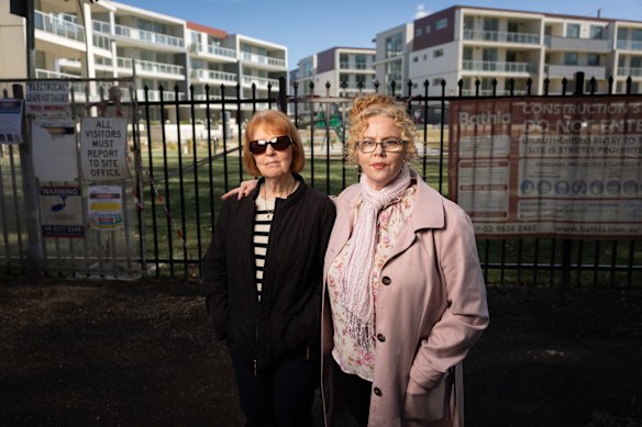 Sue Mancuso and daughter Marie Sinclair stand in front of the fenced-off Kembla Grange development.