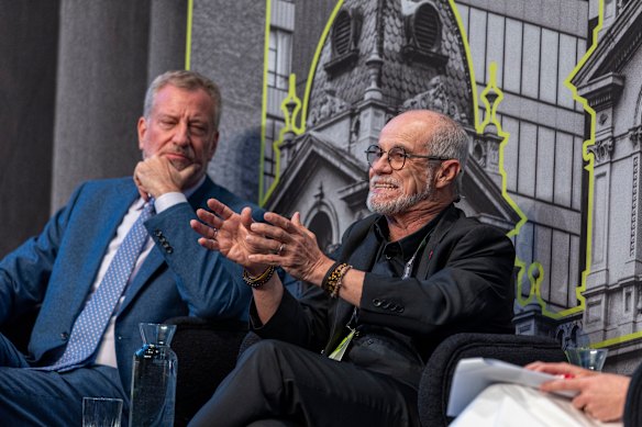 Carlos Moreno addresses the forum earlier this week as former New York City mayor Bill de Blasio listens.