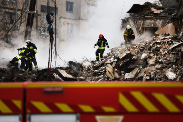 Emergency workers search through the remains of the building.