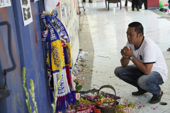A man prays for the victims of Saturday’s soccer match stampede in front of gate 13 the Kanjuruhan Stadium in Malang, Indonesia.