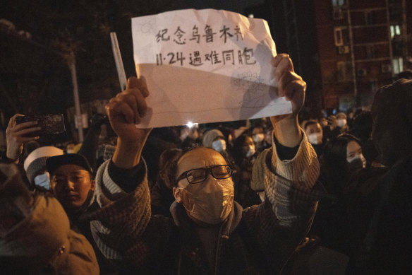 A protester holds up a sign in Beijing on Sunday.