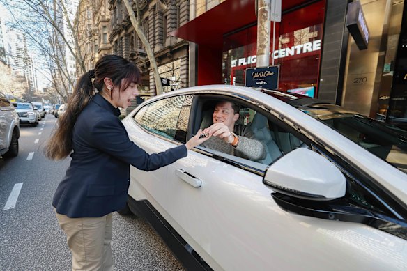 Scott Collie hands his car keys to Laura Castillo while using the valet parking service, which launches this week.