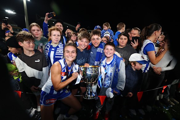 Ash Riddell celebrates with the premiership cup and fans.