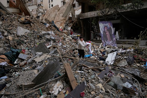A boy holds a book found in the rubble of a destroyed building, following a ceasefire between Hezbollah and Israel, in Dahiyeh, in Beirut’s south, on Monday.