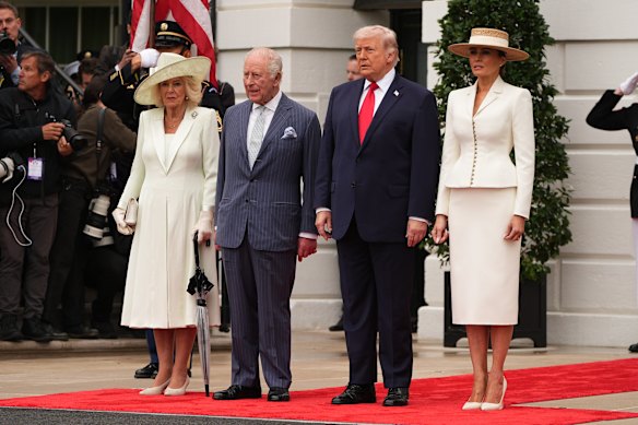 King Charles III and Queen Camilla, umbrella in hand, stand with US President Donald Trump and his wife, first lady Melania Trump, as they arrive for their ceremonial welcome on the South Lawn of the White House.