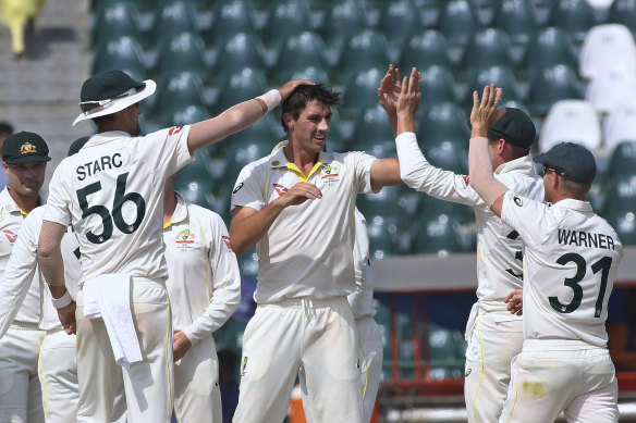 Australian captain Pat Cummins celebrates a Pakistan wicket with teammates on the final day of the third Test.