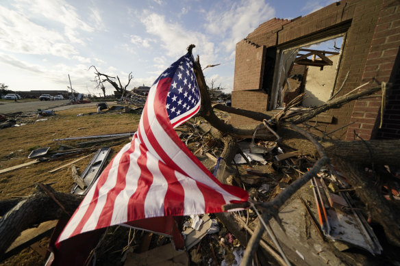 An American flag flies amidst debris of destroyed homes, in the aftermath of tornadoes that tore through the region, in Mayfield, Kentucky.
