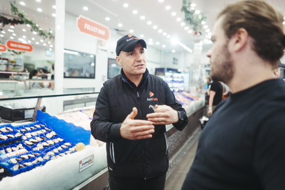 GetFish manager Carmelo Lombardo speaks with a customer as people flock to the Sydney Fish Market ahead of Christmas.