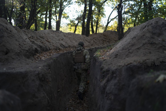 A Ukrainian serviceman checks the trenches dug by Russian soldiers in a retaken area in Kherson region.