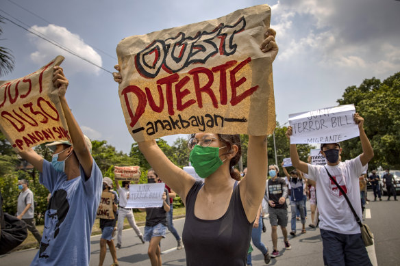 Protesters wearing masks hold up placards as they protest an anti-terror bill, President Rodrigo Duterte is trying to expedite. Rights groups warn the law contains draconian provisions that could be used to target his critics.
