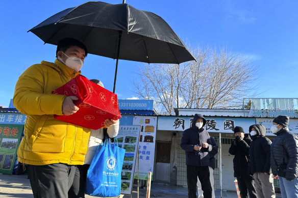 Family members collect the cremated remains of their loved one bundled with red cloth outside a crematorium in Beijing last weekend.