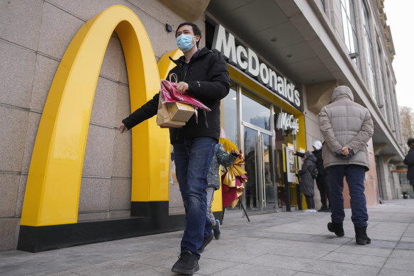 A man carries his McDonald’s takeaway in Beijing, China.