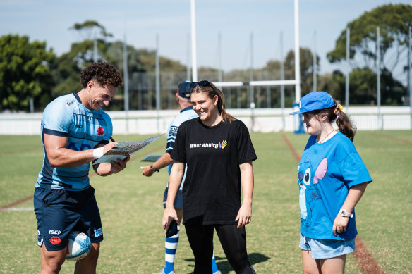 Mark Nawaqanitawase signs an autograph at Waratahs training alongside NSW women’s skipper Piper Duck. 