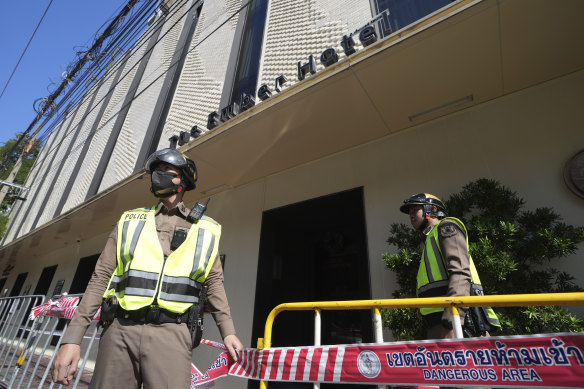 Police stand guard after The Ember Hotel fire in Bangkok, Thailand.