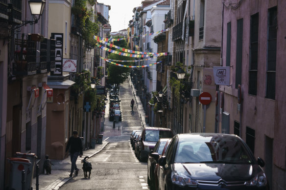 A pedestrian walks dogs along a deserted street in Madrid, Spain.