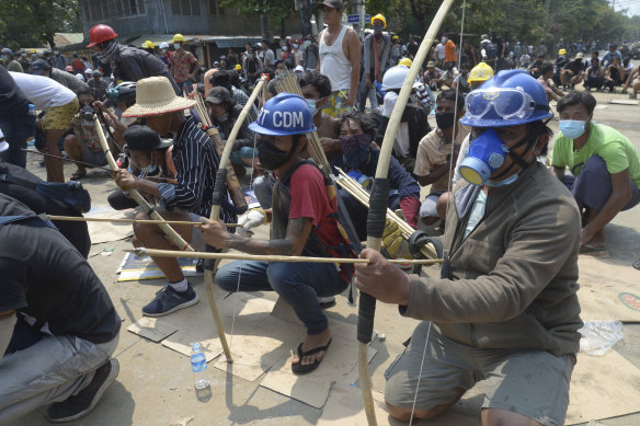 Anti-coup protesters prepare makeshift bow and arrows to confront police in Thaketa township Yangon, Myanmar, on Saturday, as more than 100 were killed by soldiers and police.