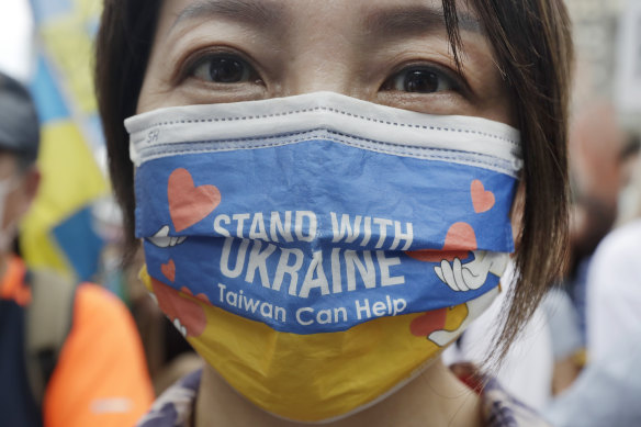 A Taiwanese woman wears a Ukraine flag-patterned mask  during a march in Taipei.