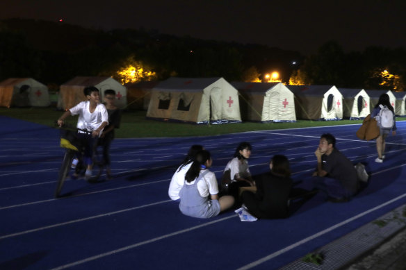 People evacuated from their homes sit outside the shelter after the main earthquake in Hualien City, eastern Taiwan.