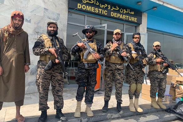 Taliban fighters stand guard inside the Hamid Karzai International Airport the day after US forces departed. 