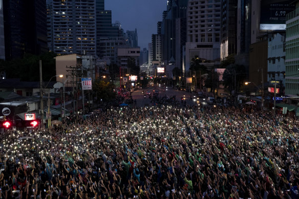 Pro-democracy supporters wave their mobile phones during a protest rally in Bangkok on Sunday.