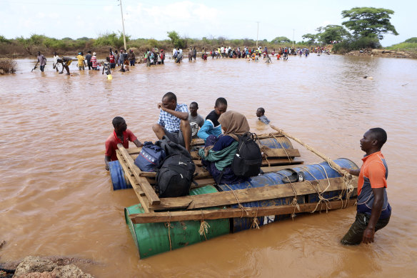 People cross a flooded area on makeshift raft in north-east Kenya in November.