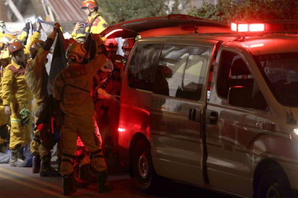 Firefighters move victims’ bodies outside a collapsed building during a rescue operation following in Hualien City.