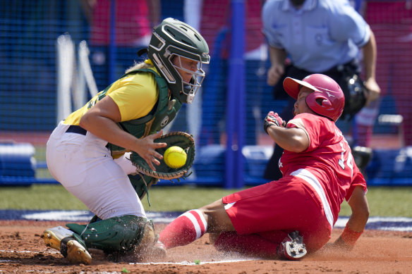 Japan’s Minori Naito, right, slides into home base as Australia’s Taylah Tsitsikronis catches the ball 