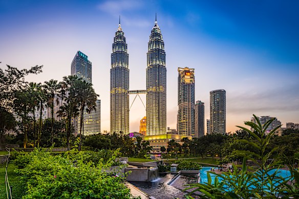 The iconic twin spires of Kuala Lumpur’s Petronas Towers rise above park in the Malaysian city’s heart. 
