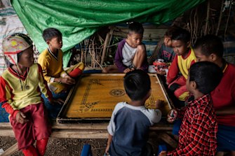 Youths play carrom between horse races. Many of the jockeys grow up in households where their brothers and fathers also once raced. 