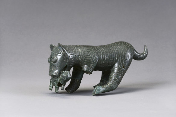 A bronze sculpture of a tiger mother with cub in its mouth from the Western Zhou Dynasty, 1046–771 BCE. 