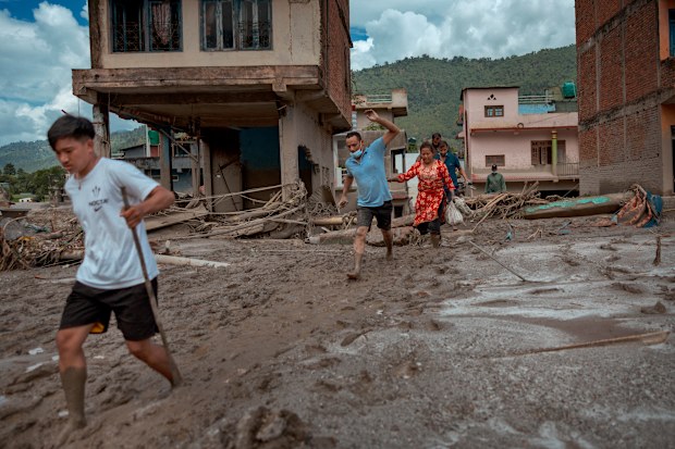 Residents run to safety after police alerted them of another possible flash flood on August 28, 2026 in Devighat, Nepal.
