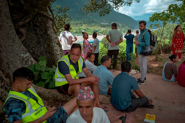 Devighat, Nepal'de, polis bir başka olası sel baskını hakkında uyardığında, Trishuli nehrini bir tepe noktasından izleyen sakinler.
