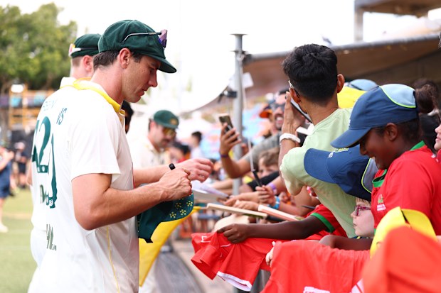 Pat Cummins signs autographs for young cricket fans.