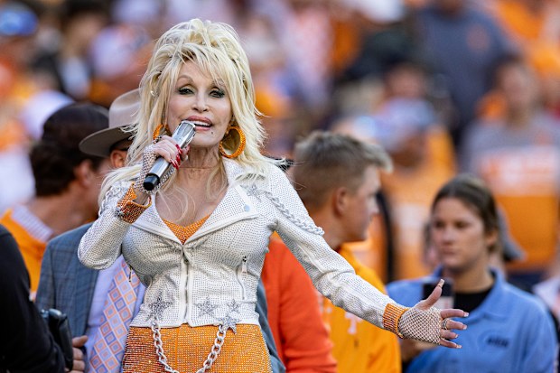 FILE - Dolly Parton performs during the first half of an NCAA college football game between Tennessee and Georgia Nov. 18, 2023, in Knoxville, Tenn. (AP Photo/Wade Payne, File)