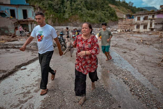 Devighat, Nepal'de, polis bir başka olası sel baskını hakkında uyardığında, güvenli bir yere koşan sakinler.