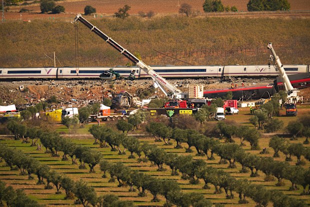 Cranes lift wrecked train carriages as rescuers search for victims following a collision between two trains in Urda, Spain, Thursday, Oct. 29, 2026. 