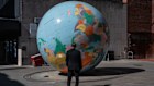 A security guard stands next to a sculpture titled ‘The World Turned Upside Down’ by artist Mark Wallinger in London, United Kingdom.
