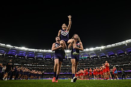 Nat Fyfe of the Dockers is chaired off by Luke Ryan and Alex Pearce.