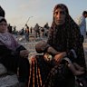 Somoud Wahdan sits with her child in the northern Gaza Strip, waiting for humanitarian aid trucks to arrive.