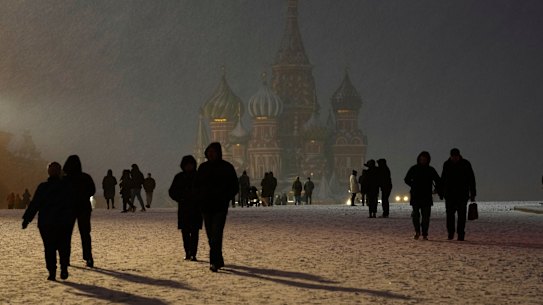 People walk in a snowy Red Square in front of St Basil’s Cathedral, during snowfall in Moscow.
