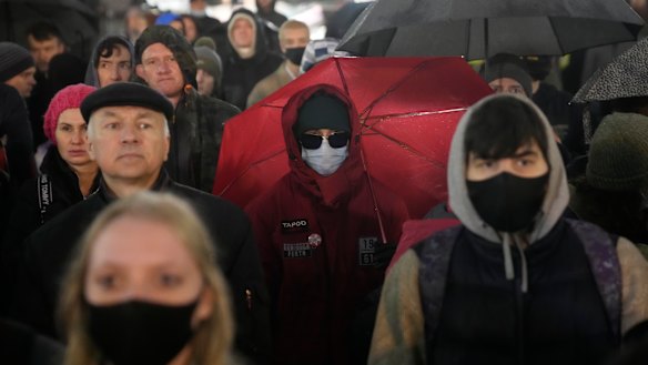 Young, hip, communist, and fed-up with corruption. People listen to a speaker during a protest against the results of the Parliamentary election in Moscow, Russia. 