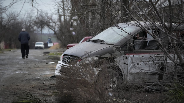 A damaged vehicle and debris following Russian shelling in Mariupol.