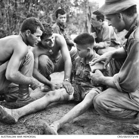 Three soldiers from the 3rd Battalion, The Royal Australian Regiment (3RAR), treat a captured North Vietnamese soldier.