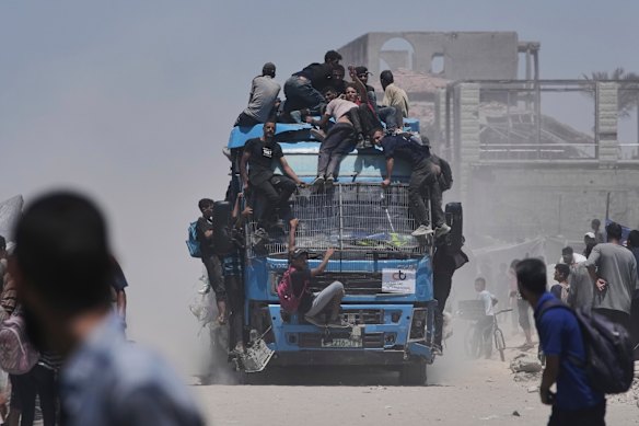 Palestinians ride on an aid truck heading into Gaza City on Tuesday.