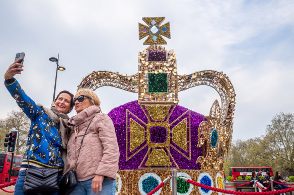 People take a selfie in front of a replica of the St Edward’s Crown.