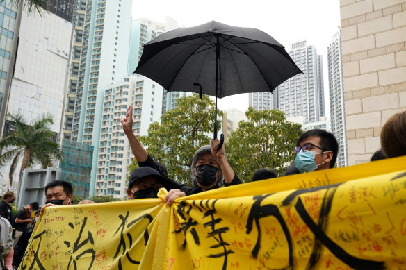 Supporters of pro-democracy activists hold a banner reading “release political prisoners” as they queue up outside West Kowloon Magistrates’ Courts in Hong Kong on Monday.