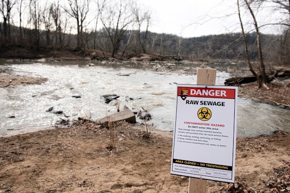 A recently placed warning sign at the site of the massive pipe rupture, as sewage flows into the Potomac River in Glen Echo, Maryland.