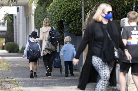 Parents collect their children from St Charles’ Primary School at Waverley after a year 3 student tested positive to COVID-19.