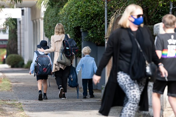 Parents collect their children from St Charles’ Primary School at Waverley after a year 3 student tested positive to COVID-19.